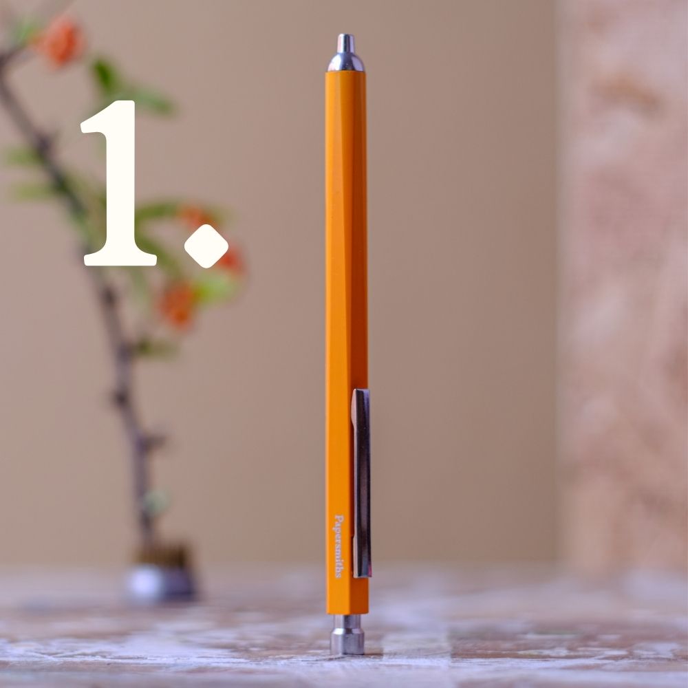 yellow pen with silver accents on a marble surface, blurred background