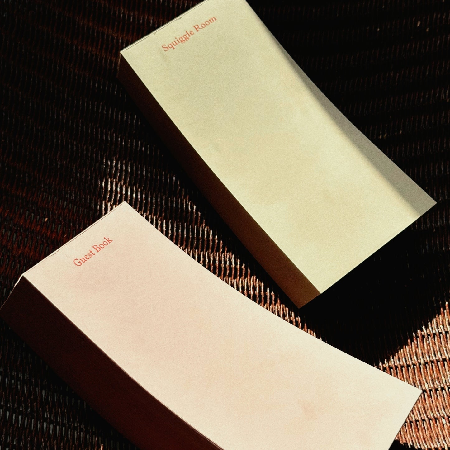 Two beige to do pads with 'Guest Room' text on a textured surface