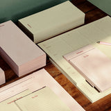 Set of stationery items including notebooks and planners on a wooden surface.