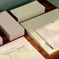 Set of stationery items including notebooks and planners on a wooden surface.