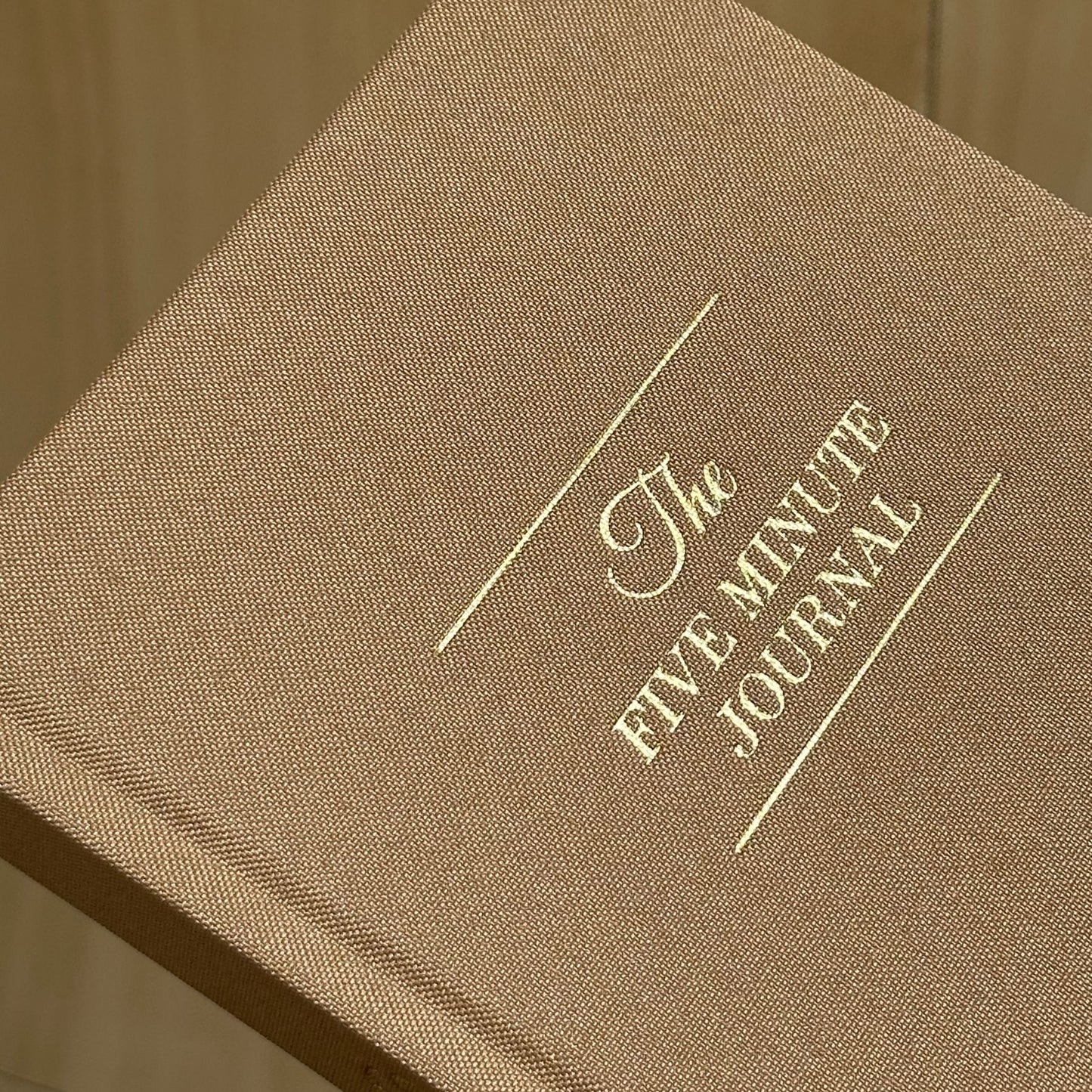 Brown journal with 'The Five Minute Journal' embossed on it