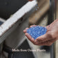 Hand holding blue plastic flakes with 'Made from Ocean Plastic' text