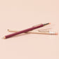 Two pocket-sized pencils with pink and beige accents on a beige background