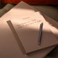 Blue pocket pen lying on a 'Schemes' note block