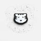 Black and white tiger face design on a textured white background